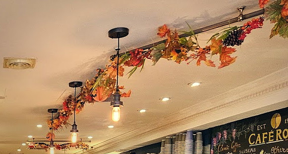 Pendant bulbs, an autumn garland and the blackboard coffee list inside Cafe Roma