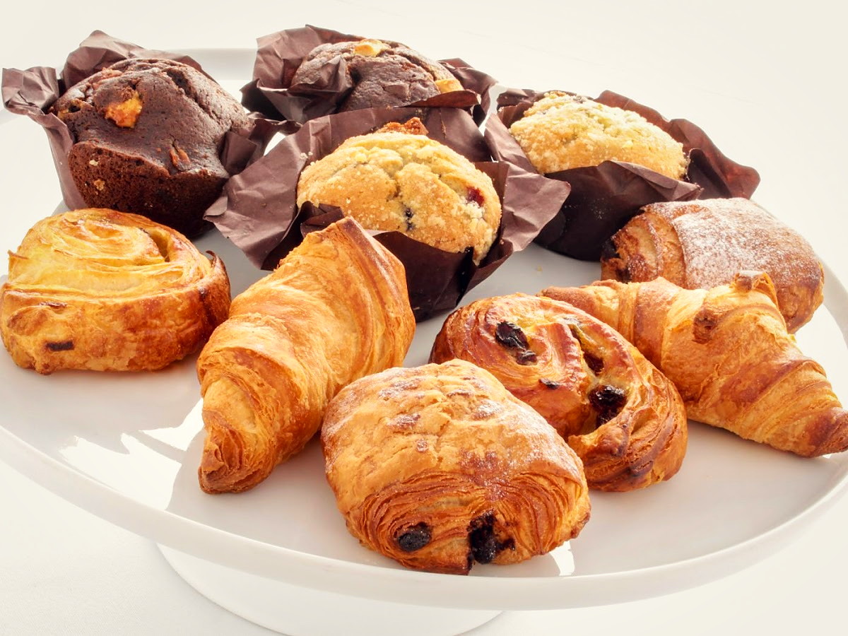 A plate of fresh croissants, pains au chocolat and muffins